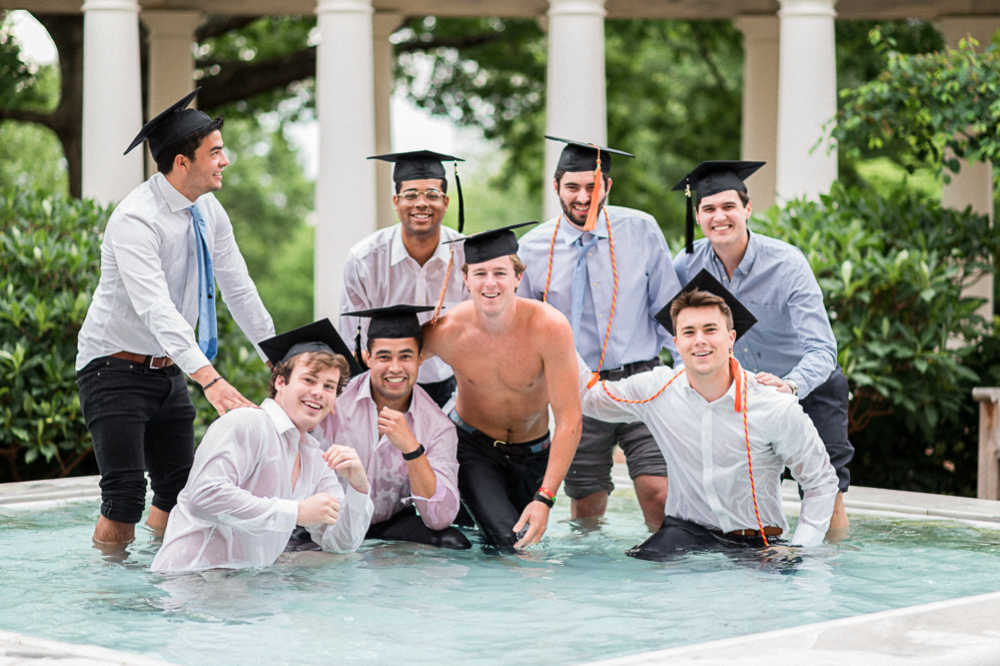 A rowdy group of college senior guys smile for the camera -- soaking wet and half-submerged in a fountain on UVA's grounds/campus.