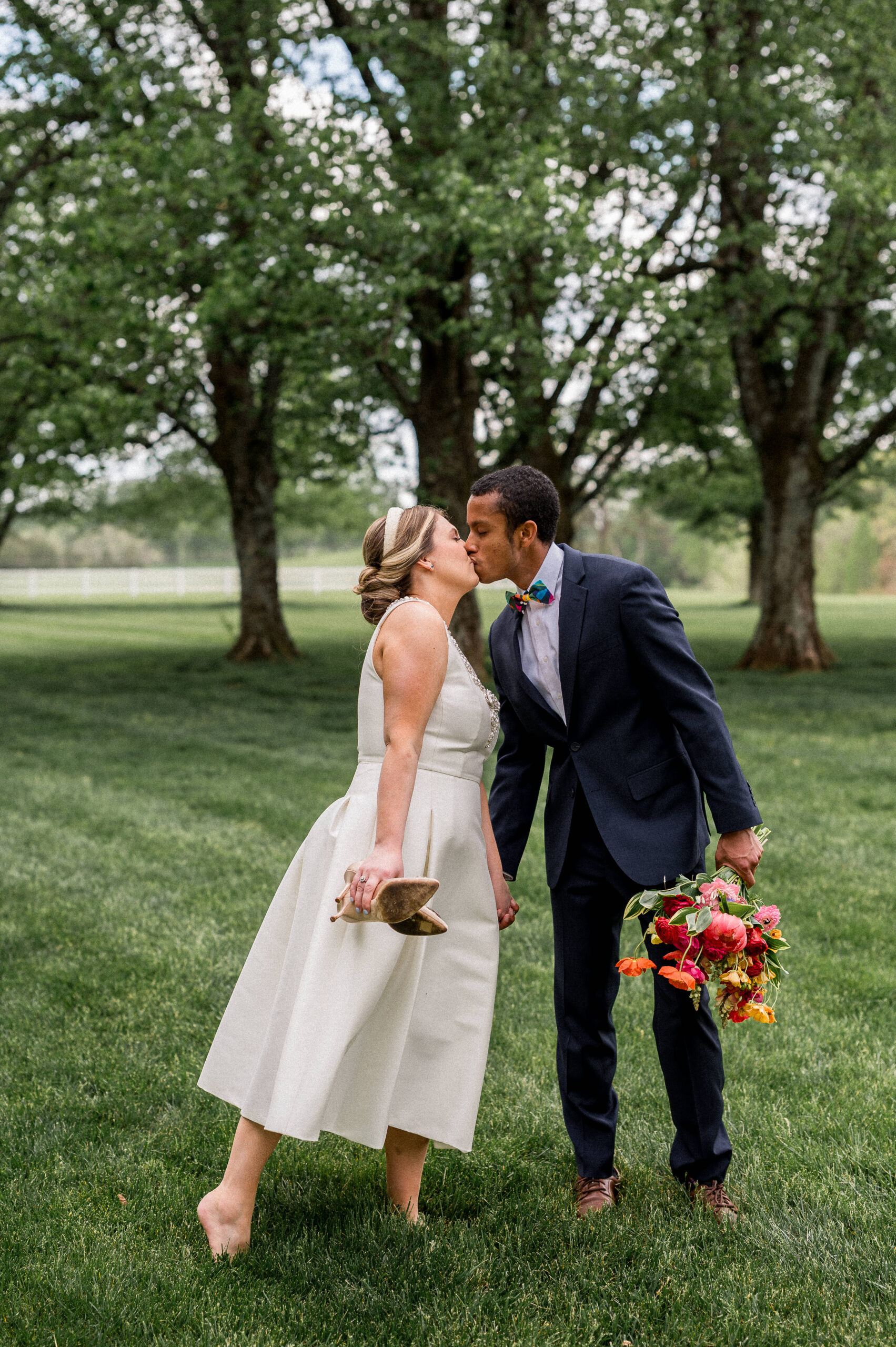 An interracial couple kisses during their Caribbean Inspired Wedding at Castle Hill Cider in Charlottesville, VA. Wedding Photography by Hunter and Sarah Photography