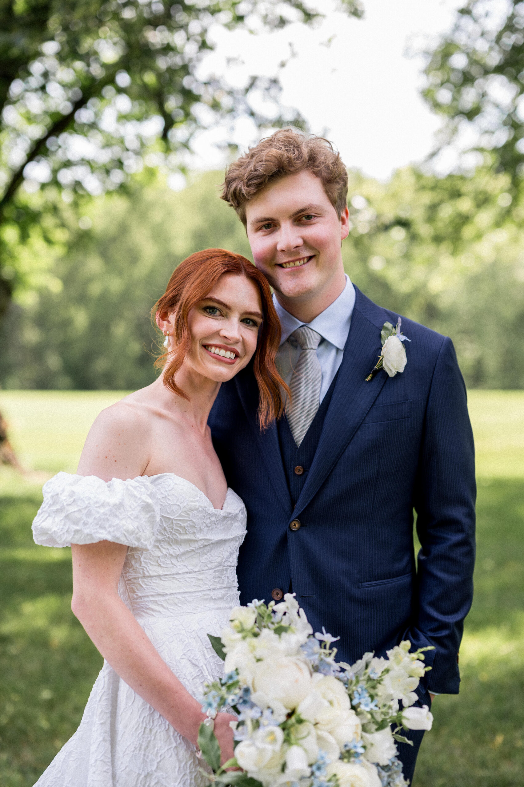 A stylish wedding couple smiles at the camera on their wedding day at Castle Hill Cider, beautifully captured by Hunter and Sarah Photography.