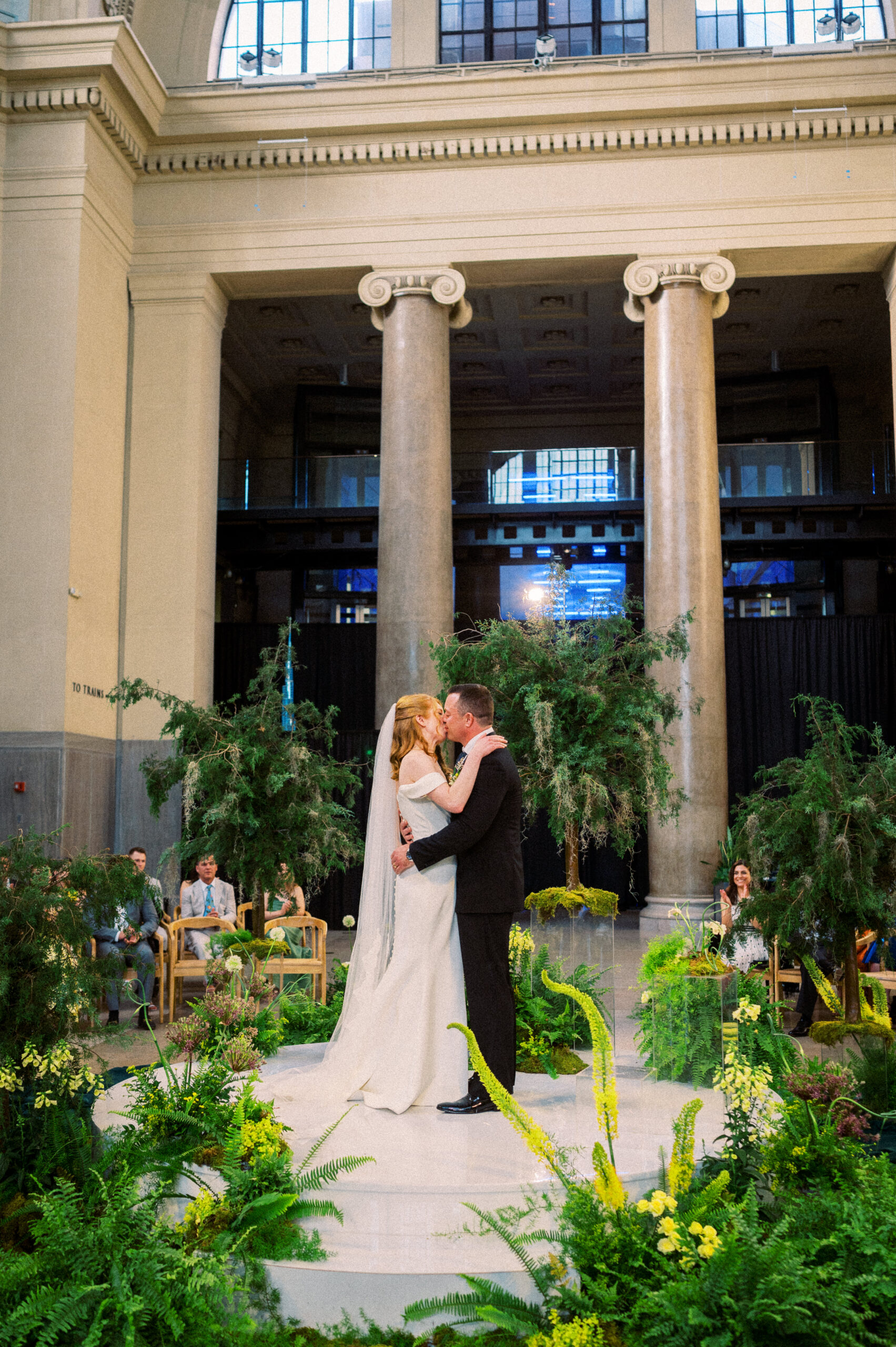 A couple embraces and kisses at the end of their ceremony during their museum wedding at Richmond's Science Museum of Virginia, beautifully captured by Hunter and Sarah Photography.