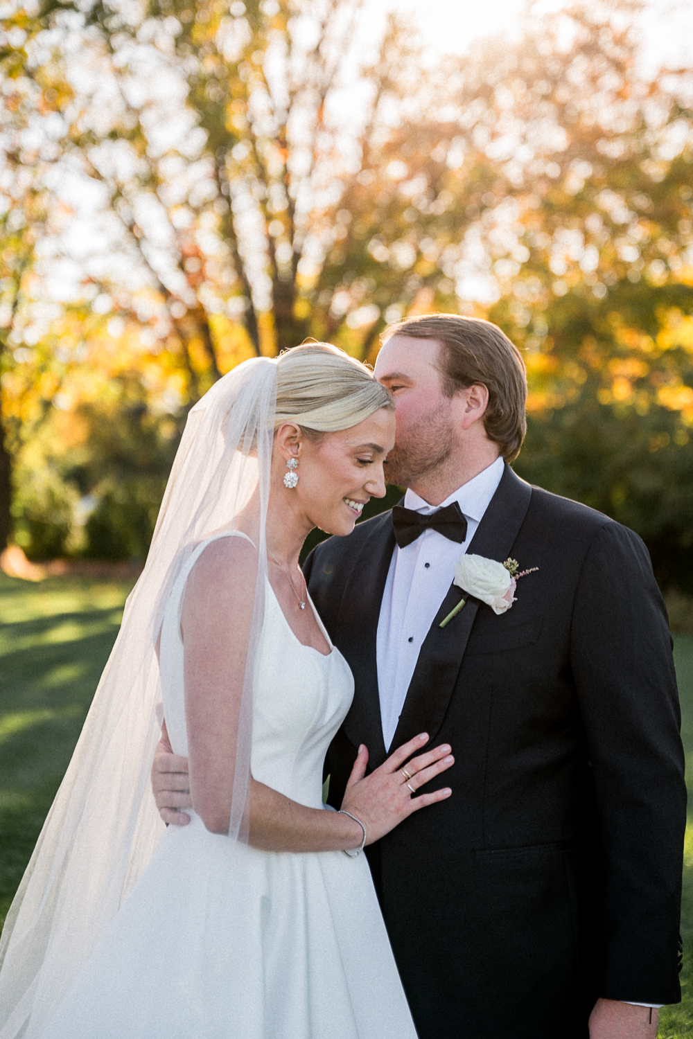 A couple kisses at sunset during their Elegant Fall Wedding at Farmington Country Club. This tight-cropped wedding portrait was beautifully captured by Hunter and Sarah Photography.