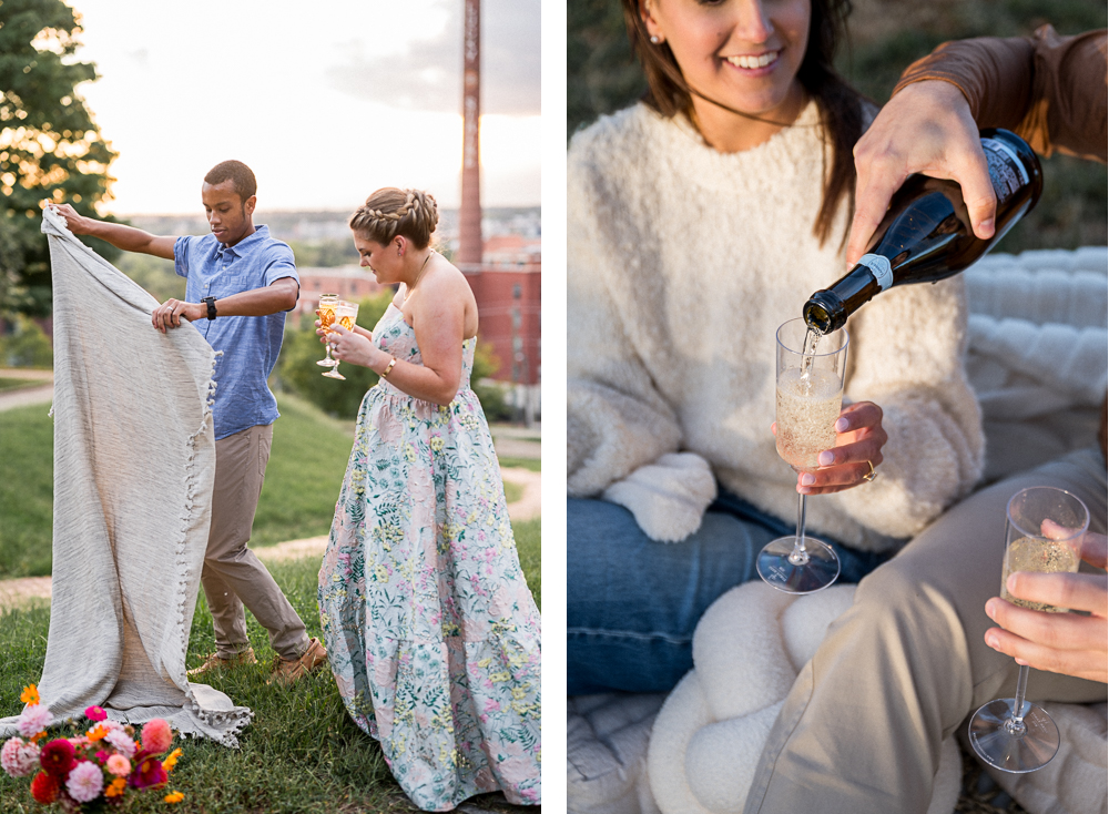 A couple prepares a picnic blanket at Libby Hill park. He's laying out a blanket while she pours champagne.